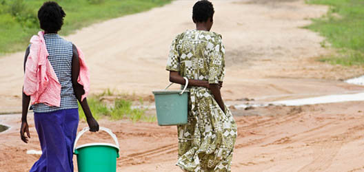 Two people collect water with buckets